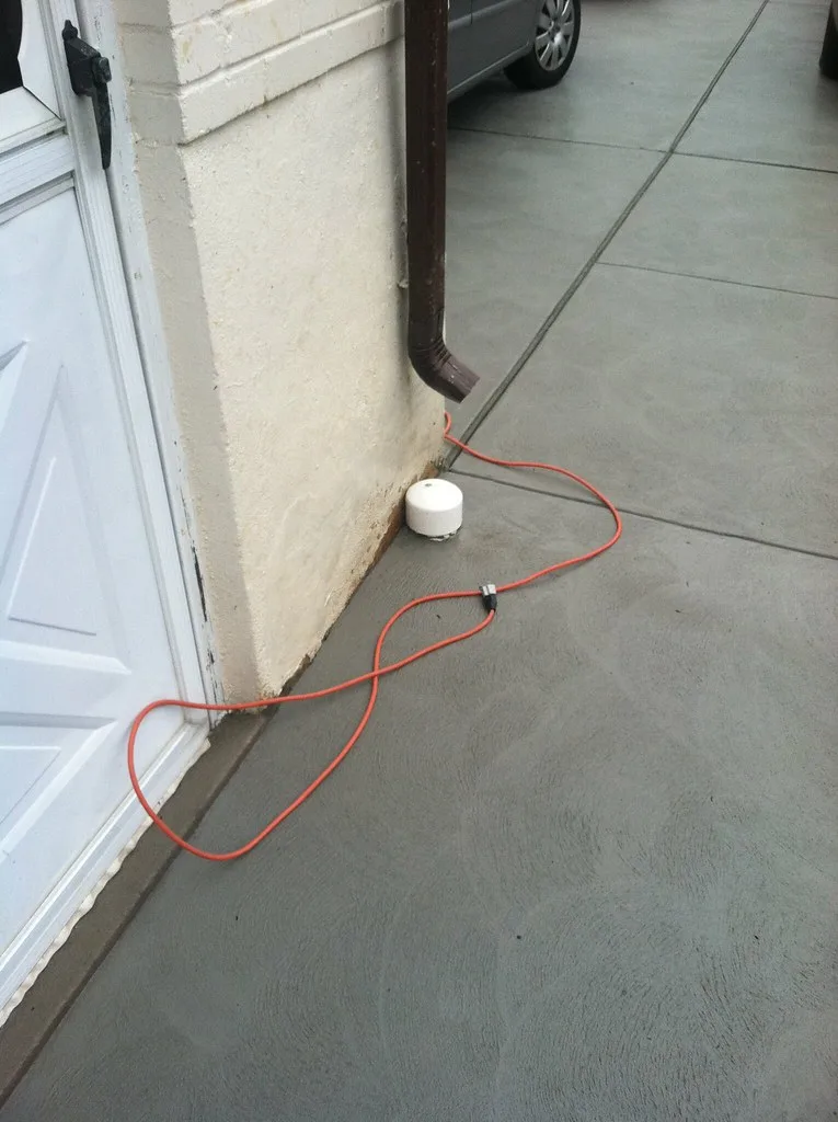 Compacted gravel base, shovel, and tape measure used to check asphalt driveway thickness
