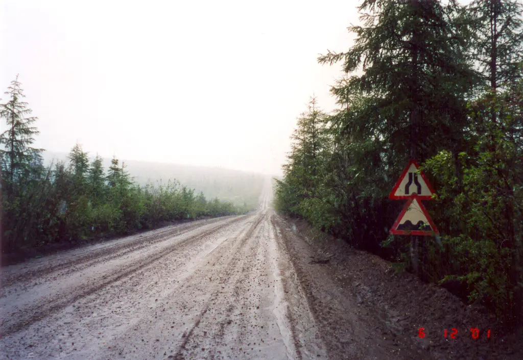 Close-up of a tape measure and shovel beside compacted road base gravel